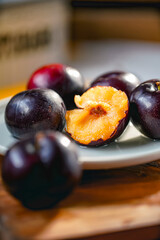 Fresh black plums on cutting board