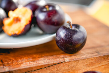 Fresh black plums on cutting board