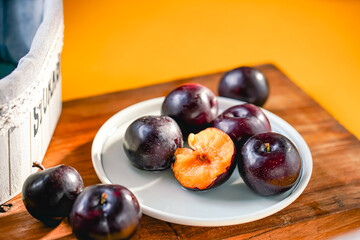 Fresh black plums on cutting board