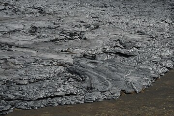 Lava flow from Fagradalsfjall eruption, Iceland. Gray and black lava crust with flow texture. 