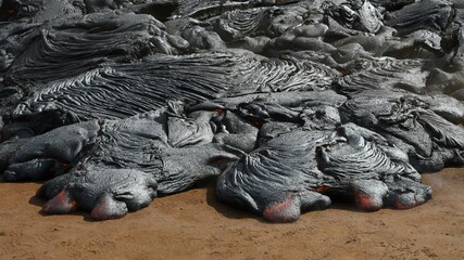 Pahoehoe lava flow at Fagradalsfjall, Iceland. Lava crust is gray and black, molten lava is red and orange.