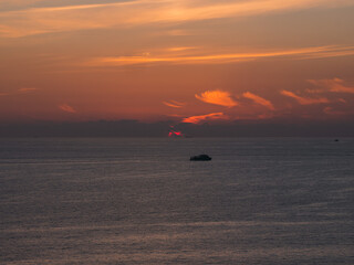 Colorful sunset at the sea with speedboat silhouette