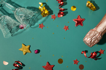 Christmas new year flat lay with champagne, glass and  stars, streamers and copy space on green background