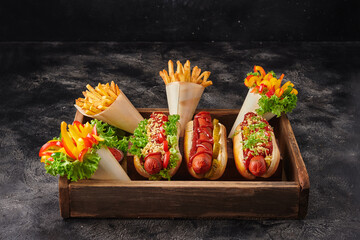 Fototapeta na wymiar French fries in white paper with holder and hot dogs
