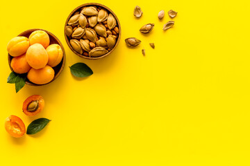 Wooden bowls of apricots and apricot kernel almond, top view
