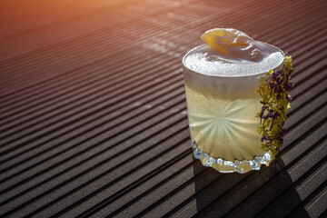 margarita pineapple cocktail in glass garnished flower on wooden background