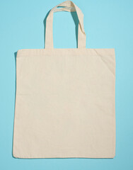 empty linen eco friendly beige canvas tote bag for branding on blue background. Clear reusable bag for groceries, mock up