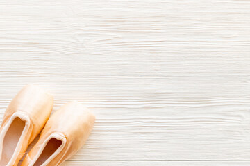 Pair of beige ballet pointe shoes with ribbon, top view