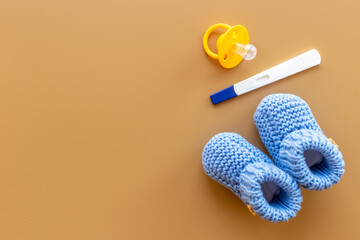 Baby boy booties with pregnancy test. Morherhood and pregnancy concept