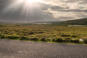 Small narrow country road in Connemara, county Galway, Ireland. Dramatic sky. Irish landscape....