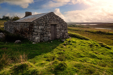 Old abandoned stone house without the roof. Sunset time. Rural Irish farm building. Dramatic sky. Old architecture example. Top quality frame . History and heritage concept. Connemara, Ireland © mark_gusev