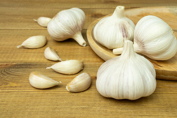 Whole heads and cloves of garlic on wooden table.