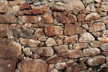 Old stone house wall texture. Warm color. Example of masonry craft and old construction technology