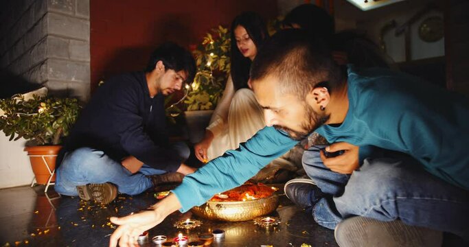 A closeup of Indian guys and girls burning candles for the Deepawali hol
