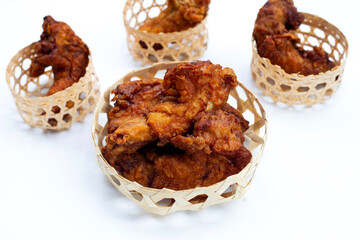 Fried chicken necks in bamboo basket on white background.