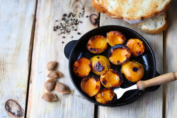 Selective focus. Halves of apricot in a frying pan. Grilled apricots for toast.