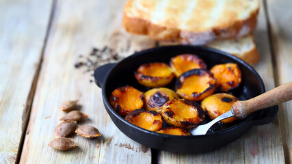 Fototapeta na wymiar Selective focus. Halves of apricot in a frying pan. Grilled apricots for toast.