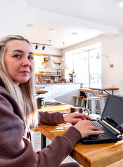 Young woman in a comfortable tracksuit works on the computer.