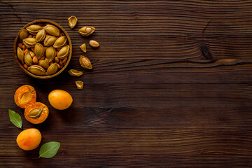 Apricots and apricot pits kernel in bowl. Overhead view