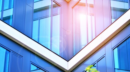 Obraz premium Modern office building with glass facade on a clear sky background. Transparent glass wall of office building.