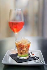 Artisanal seafood ceviche with guacamole pintxos or tapas with a blurred glass of Spanish rose or rosado in a restaurant in Pamplona, Spain