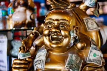 Bronze Buddha statue with Dollar Bills taped to it 