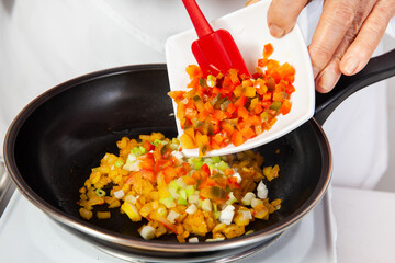 Preparation of the traditional patties from the region of Cauca in Colombia, called empanadas de pipián - Senior woman preparing the filling for the patties - Adding peppers