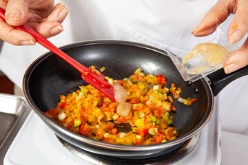 Preparation of the traditional patties from the region of Cauca in Colombia, called empanadas de pipián - Senior woman preparing the filling for the patties - Adding garlic