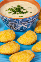Patties from the region of Cauca in Colombia, called empanadas de pipián accompanied with the traditional peanut spicy sauce