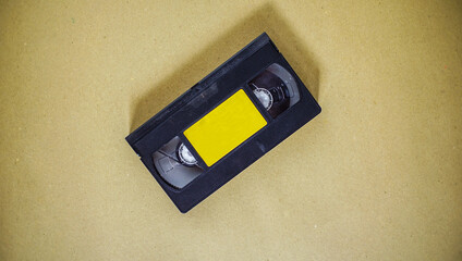 an old audio cassette has a yellow label. stuff to record and store data in a sound format. an...