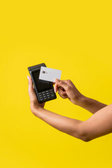 vertical de la mano de una mujer afroamericana con un sistema de cobro con tarjeta de debito o crédito 