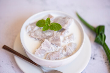 Taro food with dessert taro boiled with sugar and coconut milk on bowl and fresh raw organic taro root ready to cook, Asian Thai food