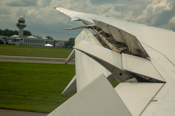 Hamowanie samolotu na pasie startowym po lądowaniu z otwartymi spojlerami i klapami