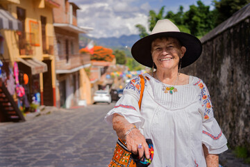 Mexican grandmother smiling at the camera. adult latina with sombrero on a sunny day.