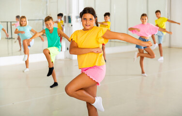 Children exercising modern dance moves together during their group classes.