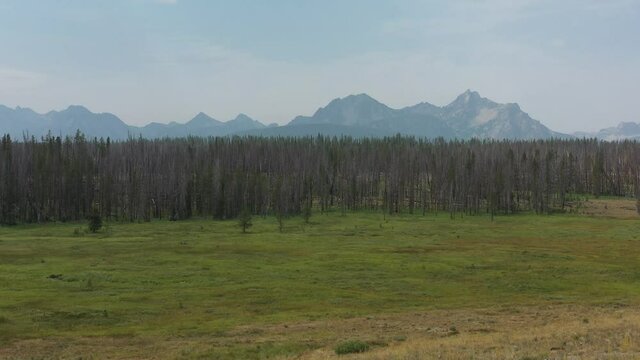 McGown Peak as seen from the Park Creek Overlook in the Sawtooth National Recreation Area near Stanley, Idaho on a summer day. The camera makes a dolly out motion to reveal a split rail zigzag wooden 