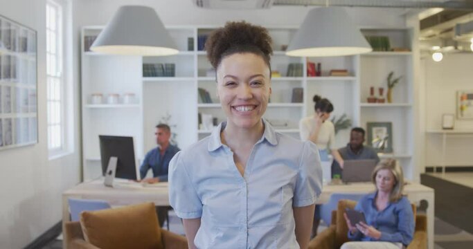 Young woman smiling to camera at the office