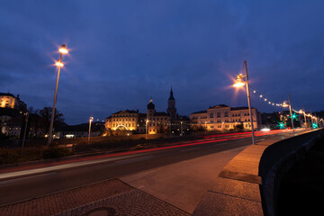 colorful light stripes of cars on the street at night in front of a church in the city of plauen