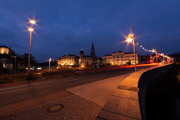 Obraz premium colorful light stripes of cars on the street at night in front of a church in the city of plauen