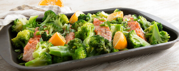 baking sheet with broccoli and salmon on the table