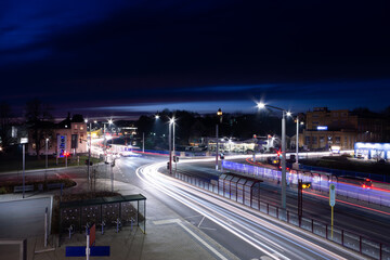 colorful light stripes of cars on the street at night in front of a church in the city of plauen