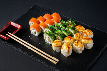 Assortment of fresh prepared sushi on black background.