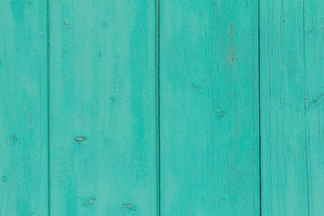 Fototapeta premium A fragment of an old wooden door or wall of blue or turquoise color .