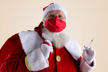 Santa Claus smiles behind red Covid-19 safety face mask. Christmas with social distance.