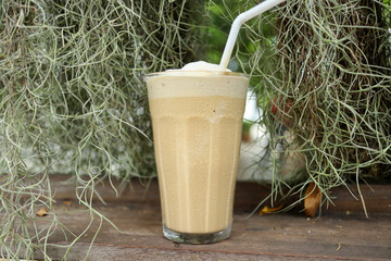 Latte frappe coffee in a coffee shop of natural ambient - refreshing and relaxation concept