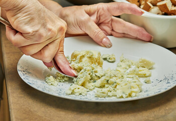 Obraz na płótnie Canvas With a fork, the chef kneads mashed potatoes on plate