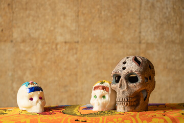 Traditional sugar skulls of the Mexican celebration of the Day of the Dead accompanied by a prehispanic clay skull