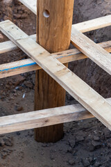 A wooden log fixed with struts in a pit, before pouring concrete. Vertical foto