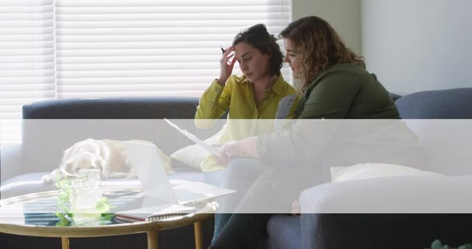 Animation of love and pride over lesbian couple doing paperwork