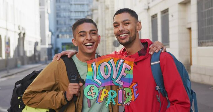 Animation of love and pride over gay couple embracing on street